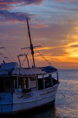 Karayip Denizi kıyısında sakin bir akşam: Güneş, Gökyüzünü Turuncuya ve Kızıla boyar gibi demirlemiş balıkçı tekneleri.
