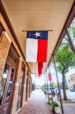 Teksas, Abilene 'de Teksas Star Ticaret binasının dış tarafında asılı bir Teksas bayrağı olan hareketli bir cadde. Yüksek kalite fotoğraf