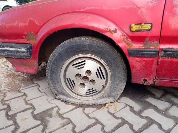 Abandoned car with a flat tire.