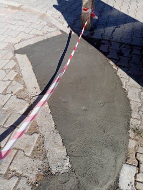 Yere yeni çimento döküldü ve güvenlik şeridi. Islak çimento.