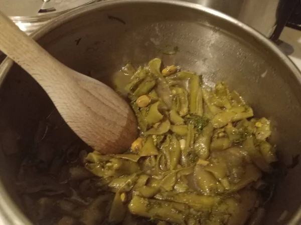 広い豆の食事は木製のスプーンで鍋に — ストック写真