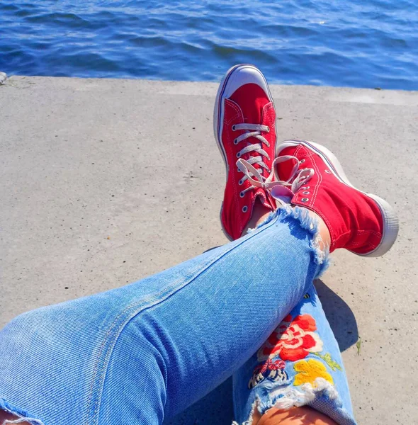 Meisje Gescheurde Jeans Rode Sneakers Meisjes Benen Uitzicht Zee — Stockfoto
