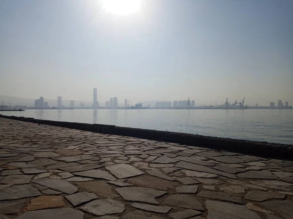 Lightly foggy weather. City and sea view. No filter. Natural day light. Sun is shining.