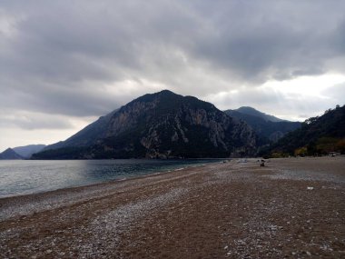 Kumsal, dağlar ve bulutlar