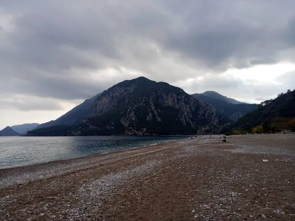 Kumsal, dağlar ve bulutlar