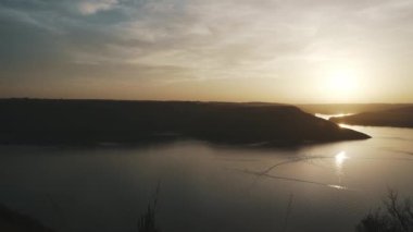 Nehir ve tepelerin ardında güzel bir günbatımı.