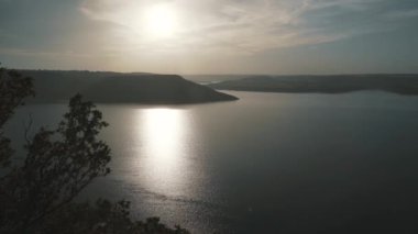 Nehir ve tepelerin ardında güzel bir günbatımı.