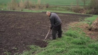 Bir adam kürekle bahçe kazıyor..