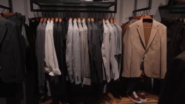 Erkek ceketi ve diğer giysiler askıda asılı..