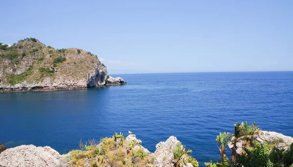 Akdeniz kıyısındaki Taormina, Sicilya, İtalya, Avrupa ve AB kıyı şeridinde Blue Grotto 'nun girişindeki turizm adası Isola Bella' nın panoramik manzarası. 