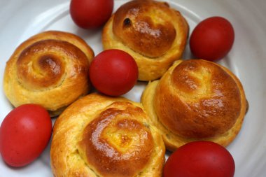 Paskalya çöreği ve kırmızı yumurtalar kasede. Romanya geleneksel yemekleri. Romen tatlı ekmeği