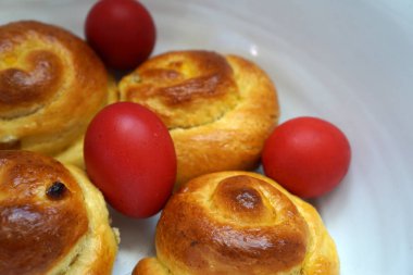 Paskalya çöreği ve kırmızı yumurtalar kasede. Romanya geleneksel yemekleri. Romen tatlı ekmeği