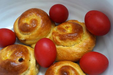 Paskalya çöreği ve kırmızı yumurtalar kasede. Romanya geleneksel yemekleri. Romen tatlı ekmeği