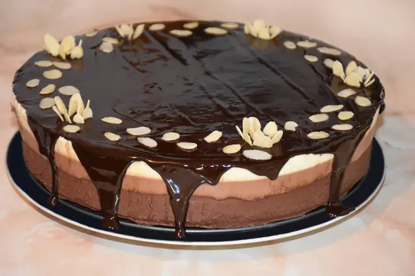 Triple chocolate mousse cake with chocolate mirror glaze and almond flakes. High quality photo