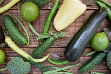 Hafif ahşap arka planda taze yeşil sebzeler. Diyet yeşil organik sebzeler