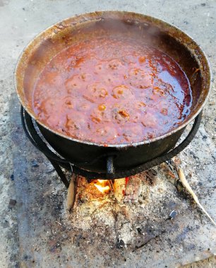 Zacusca- Romanya yemek hazırlığı. Kazanda odun ateşinde Romen akuskası pişirmek. Yüksek kalite fotoğraf