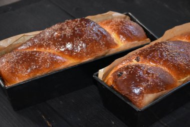 Cevizli Romen tatlı ekmeği. Cozonac, geleneksel Romen sünger keki. Noel ve Paskalya tatlı ekmeği tepsilerde siyah ahşap bir arka planda