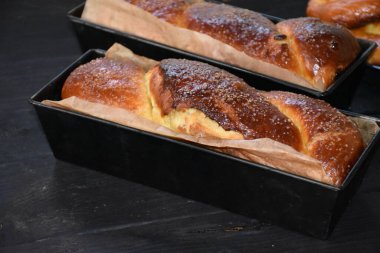 Cevizli Romen tatlı ekmeği. Cozonac, geleneksel Romen sünger keki. Noel ve Paskalya tatlı ekmeği tepsilerde siyah ahşap bir arka planda