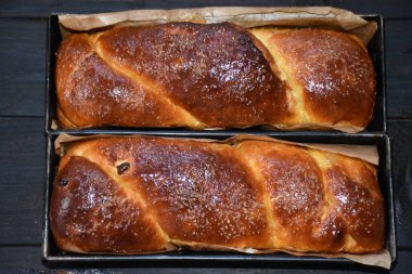 Cevizli Romen tatlı ekmeği. Cozonac, geleneksel Romen sünger keki. Noel ve Paskalya tatlı ekmeği tepsilerde siyah ahşap bir arka planda