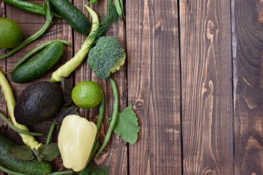 Hafif ahşap arka planda taze yeşil sebzeler. Diyet yeşil organik sebzeler