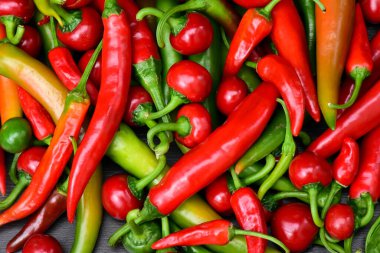 Acı biber yığını, yazı için boşluk ile sınırdır. Farklı yeşil ve kırmızı kırmızı kırmızı biberler beyaz arka planda izole edilmiş. Kiraz ve küçük acı biber.
