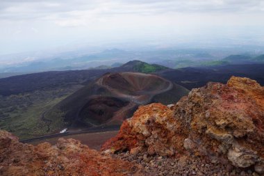 Silvestri krateri İtalya, Sicilya 'daki Etna Dağı' nın yamaçlarında lav kayaları oluşumunun arkasında görüldü. Sicilya 'da Etna volkanına yakın lav kayaları ve arka planda Silvestri volkanı.