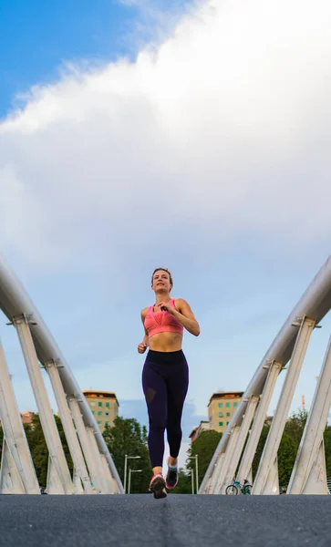 vertical photo of strong woman running in the city, copy space, fitness concept