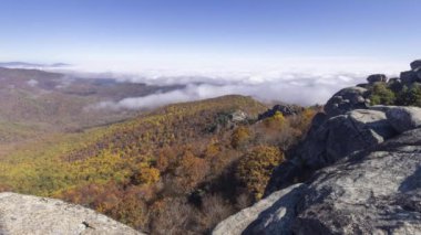 Virginia, Madison County 'deki Shenandoah Ulusal Parkı' ndaki Eski Paçavra Dağı zirvesinde güzel bir sonbahar günü. Zaman aşımına uğramış bir video, renkli ormanlar, tarlalar ve tepeler üzerinde hareket eden bir bulut tersini yakalıyor..