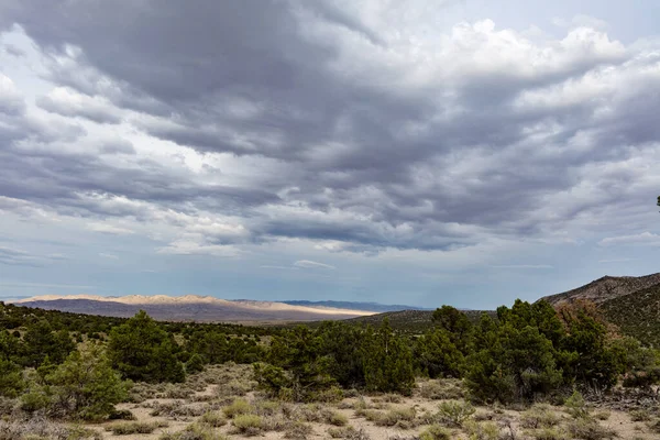 Yağmur bulutları bir yaz akşamı Büyük Havza Çölü ve Nevada 'nın güneyinde Utah Sınırı yakınlarındaki Bahçe Çölü' nde toplanır. Güneş ışınları bulutları delip geçiyor. Uzaktaki bir dağı aydınlatıyor.