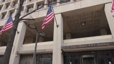 Federal Soruşturma Bürosu 'nun (FBI) merkezi olan J. Edgar Hoover Binası' nın iş atamaları girişi, Washington, DC 'de, Pennsylvania Bulvarı' nda. Kamera soldan sağa dönüyor..