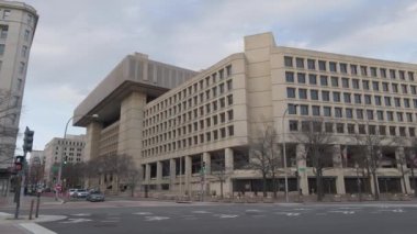 Washington 'daki Federal Soruşturma Bürosu' nun (FBI) genel merkezi J. Edgar Hoover Binası, bir kış öğleden sonra Pennsylvania Avenue NW ve 10. Cadde 'den görüldü. Kamera soldan sağa dönüyor..