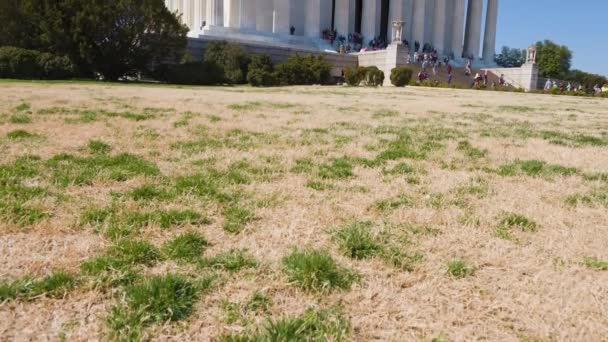 在冬末的一天 游客们参观了华盛顿国家广场上的林肯纪念堂 摄像机从草地上向大楼倾斜了一下 — 图库视频影像