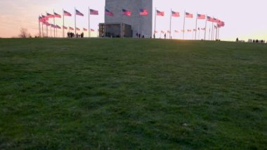 Kış sonlarında gün batımında Washington Anıtı 'nın tamamını gösteren eğik bir çekim. Tanımlanamayan çok sayıda turist, Washington, D.C. 'deki National Mall' daki popüler yeri ziyaret ediyor..