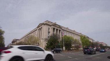 ABD Adalet Bakanlığı Robert F. Kennedy binası Washington, D.C. şehir merkezinde bir bahar günü Constitution Avenue NW ve 10th Street NW 'den görüldü. Statik, düşük açılı geniş açılı çekim.