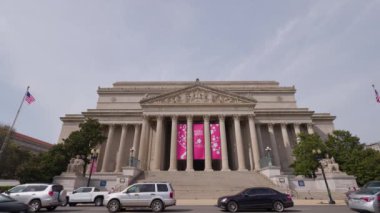 National Archives (NARA), Washington, DC 'de bir bahar günü, Constitution Avenue NW' den görüldü. Arabalar ve insanlar geçiyor. Geniş açı.