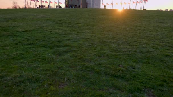 Przechylone Ujęcie Pierścienia Amerykańskich Flag Podnóża Pomnika Waszyngtona Widziane Zachodzie — Wideo stockowe