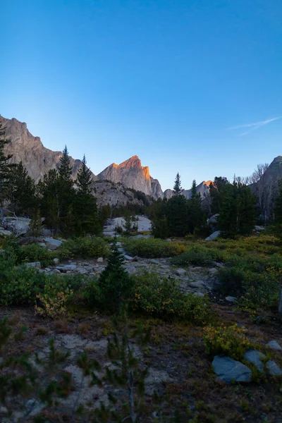 Sabah alpenglow Pusu Tepesi 'ni aydınlatıyor Geikie Dağı' nın kuzeyi ve Wyoming 'in Rüzgar Nehri Dağları' ndaki Baskın Tepesi 'nin güneyi..
