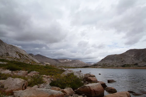 Wyoming 'in Rüzgâr Nehri Dağları' ndaki 10555 / Buzul Gölü üzerinde bir yağmur fırtınası esiyor. Yuvarlak Dağ, gölün kuzeybatısında, uzaklıktan görülüyor..