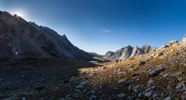Güneş doğudaki tepelerin üzerinden doğarken bir sırt çantalı Raid / Bonneville Geçidi 'ne çıkıyor. Wyoming 'in Rüzgar Nehri Dağları' ndaki Rüzgar Nehri Yüksek Yolu.