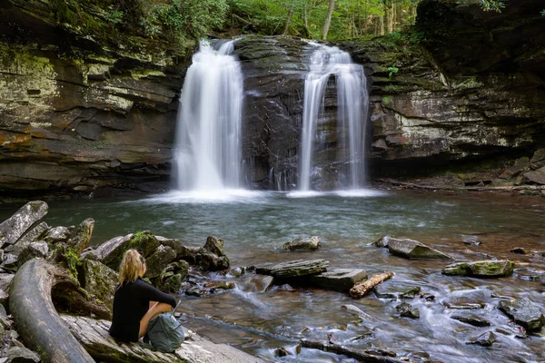 Batı Virginia 'daki Monongahela Ulusal Ormanı' nın bir parçası olan Spruce Knob / Seneca Rocks Ulusal Dinlenme Bölgesi 'nde Seneca Şelalesi' nin aşağısında bir kadın oturuyor..