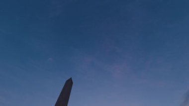 Washington Anıtı 'nın, Washington DC' de bir kış akşamı günbatımında, siluette sayısız turistin görüntüsü.