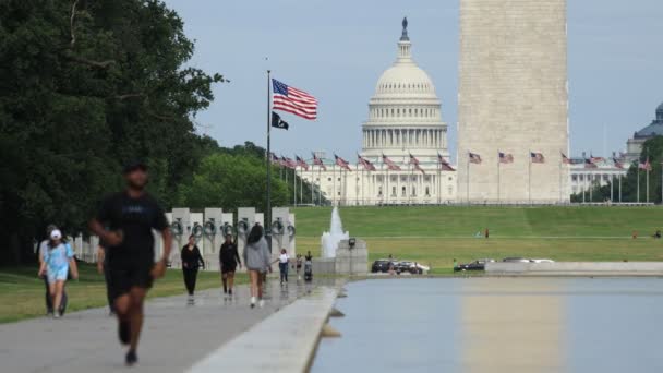 行人在反光池边走着 华盛顿纪念碑和美国国会圆顶塔的底座就在后面 — 图库视频影像