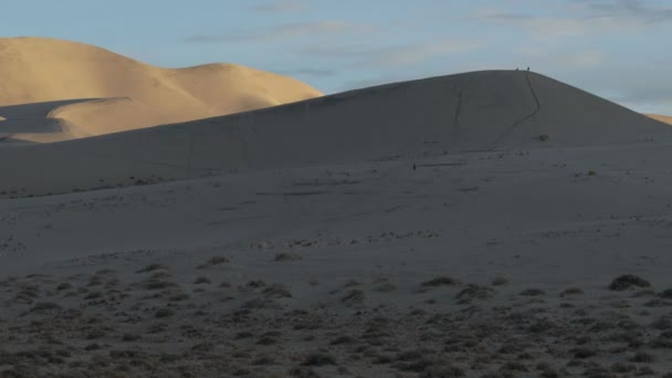 在加州死亡谷国家公园的尤里卡沙丘 落日的时间差 有人看见几个游客在沙丘上散步 — 图库视频影像