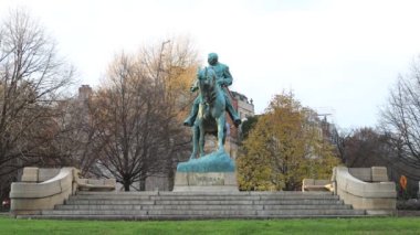 General Philip Sheridan 'ın binicilik heykeli. Washington' daki Massachusetts Bulvarı 'ndaki Sheridan Circle' da. Sonbahar günü gün batımında. Araç trafiği geçiyor..