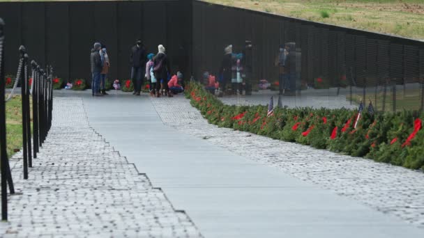 Святкові Вінки Лежали Вздовж Стіни Меморіалу Ветеранів Єтнаму Сімейна Група — стокове відео