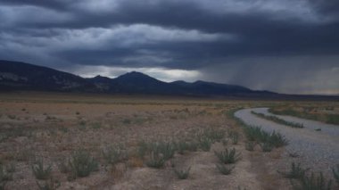Büyük Havza Ulusal Parkı ve Baker, Nevada yakınlarındaki Yılan Dağları 'nda yağmur bulutları toplanıyor. Fırtınanın hızlanması gökyüzünü süpürüyor ve karartıyor.