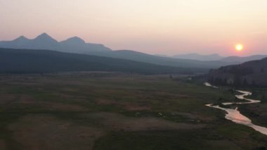 Valley Creek 'in Stanley, Idaho' da bir yaz akşamı günbatımında çekilmiş fotoğrafı. Kamera soldan sağa doğru izler..