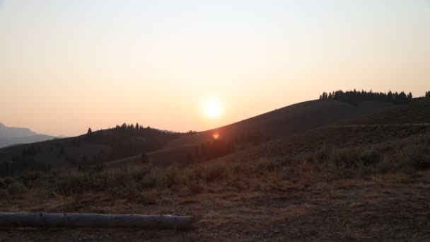 夏天的傍晚 太阳落山后 在萨牙牙国家娱乐区爱达荷州斯坦利以北的 Nip Tuck Road 由于森林大火的烟雾 太阳发红了 — 图库视频影像