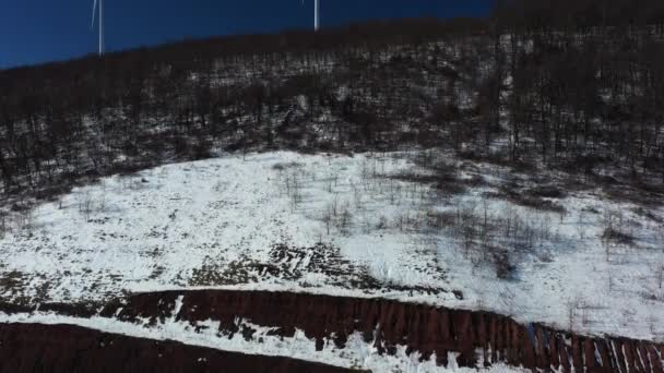 阿巴拉契亚山上被雪覆盖的风力涡轮机的空中拍摄 照相机从公路到山顶作基座的运动 以揭示涡轮机和地平线 — 图库视频影像