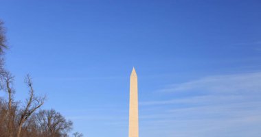 Washington Anıtı ve Washington, DC 'deki ABD Kongre Binası' nın yavaş çekimde çekilmiş görüntüleri. Turistler kışın öğleden sonra Lincoln Anıt Havuzu 'nun yanında yürürler.. 
